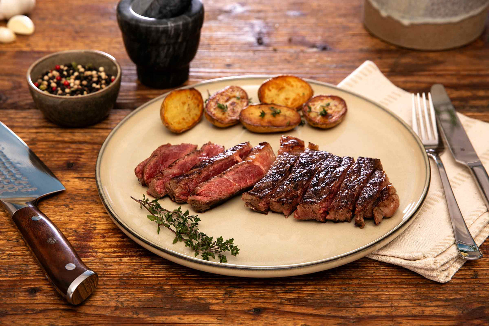 Gegrilltes deutsches Wagyu Rumpsteak, in Scheiben geschnitten und mit gebratenen Kartoffeln auf einem Teller serviert.