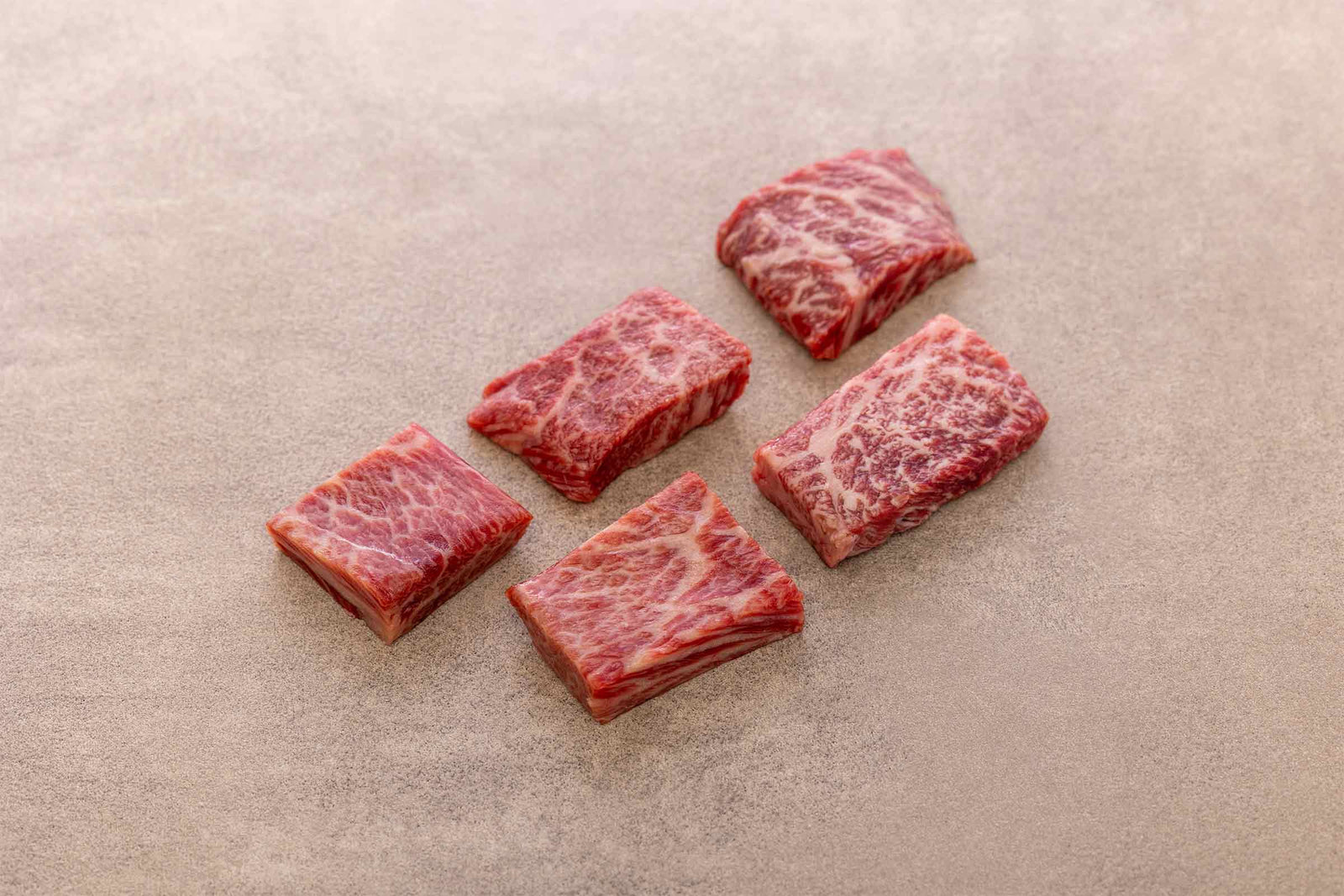 Fünf rohe Japanese Cut Stücke aus deutschem Wagyu-Rindfleisch von Gut Wagyu mit feiner Marmorierung.