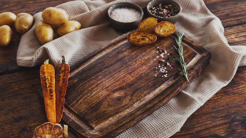 Zubereitung eines deutschen Wagyu Steaks von Gut Wagyu – gebratenes Wagyu-Rindfleisch wird auf einem Holzbrett aufgeschnitten und mit Kartoffeln und Rosmarin angerichtet.